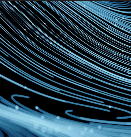 Abstract image of blue light trails against a dark background.