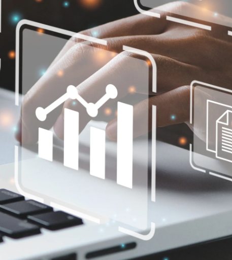 Close-up of a hand on a laptop keyboard with overlay graphics of charts and documents.
