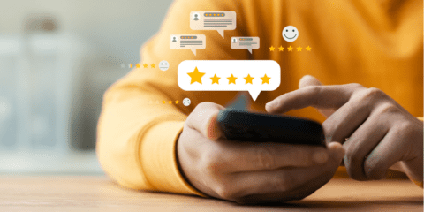 Person in yellow shirt using a smartphone, surrounded by digital review icons featuring stars and comments.