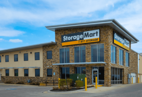 Exterior view of a Storage Mart facility with stone walls and large windows.