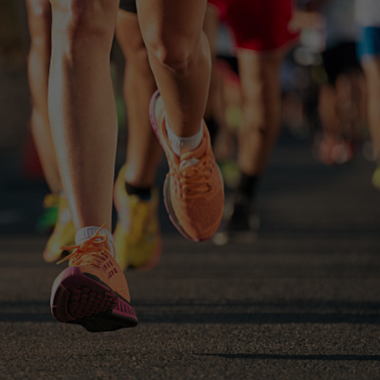 People running in a marathon, focused on the legs and feet of the participants.