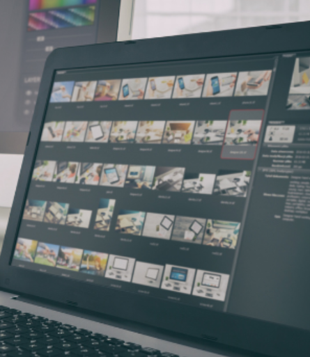Laptop displaying a photo editing software with multiple image thumbnails.