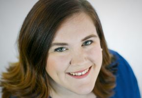 Smiling woman with shoulder-length brown hair wearing a blue top.