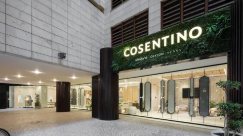 Exterior view of Cosentino showroom with illuminated signage, featuring a glass façade and modern design elements.