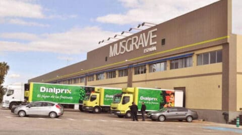 Exterior of a Musgrave España warehouse with Dialprix delivery trucks parked outside.