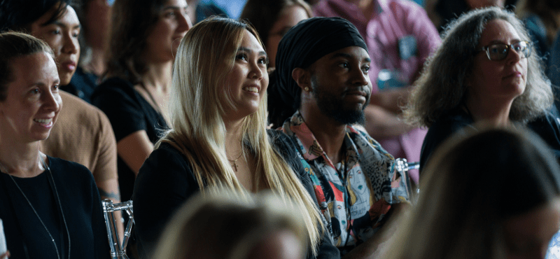 A diverse group of people attentively listening at a seated event.