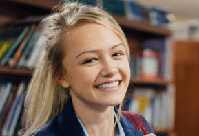 Smiling young woman in a library.