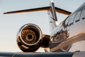 Close-up of a jet engine on a private aircraft against a clear sky.