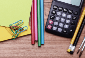 Calculator, paper clips, colored pencils, empty yellow envelopes, and pencils on a wooden surface.