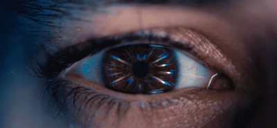 Close-up of a human eye with a reflection of a circular pattern in the pupil.