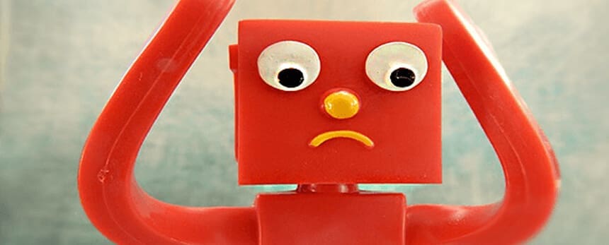 Red toy figure with a sad face and raised arms.