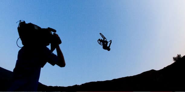 Silhouette of a BMX backflip being filmed