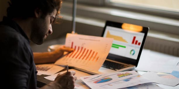 Researcher comparing reports at his desk