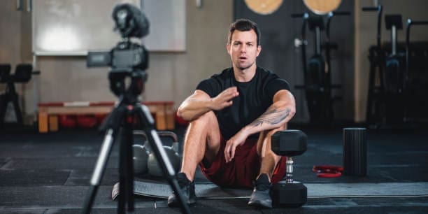 Fitness vlogger making a video of himself at the gym talking to the camera