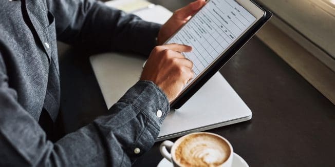 Captura de un hombre irreconocible usando una tablet mientras está sentado en una cafetería