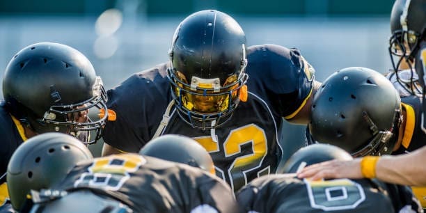 American football players in a team huddle