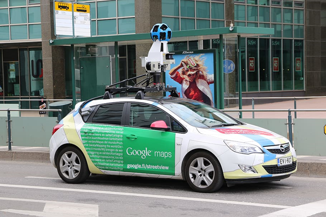 Google Street View car with mounted camera system on a city street.